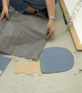 Händer jobbar med material på golvet