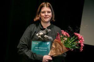 Filmare Ylva Ottervald Flygare med blommor och diplom i famnen.