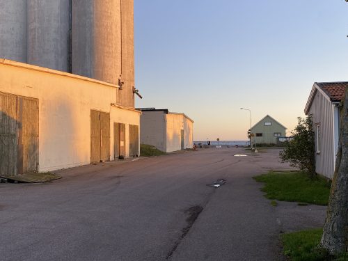 Stora industribyggnader i morgonljus med molnfri himmel