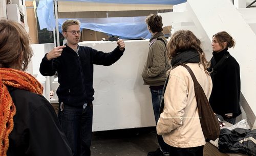 Kille gestikulerar och pratar framför ett frigolitblock